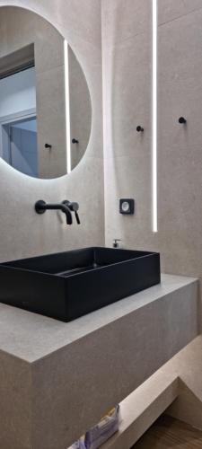 a bathroom with a black sink and a mirror at Xenia Residence in Faliraki