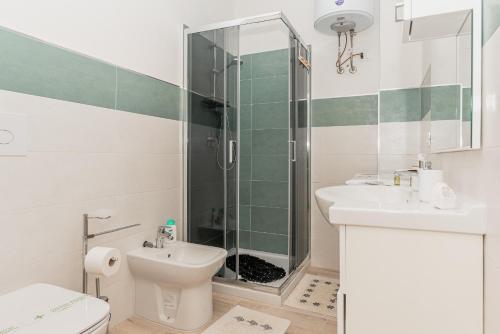 a bathroom with a shower and a toilet and a sink at Cala Lupo Relax Veranda e BBQ nel verde in Stintino