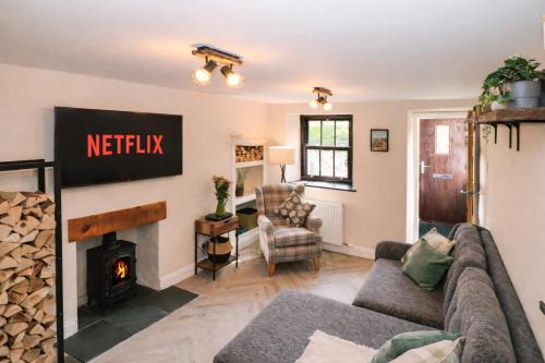 a living room with a couch and a fireplace at Fellside Cottage in Shap