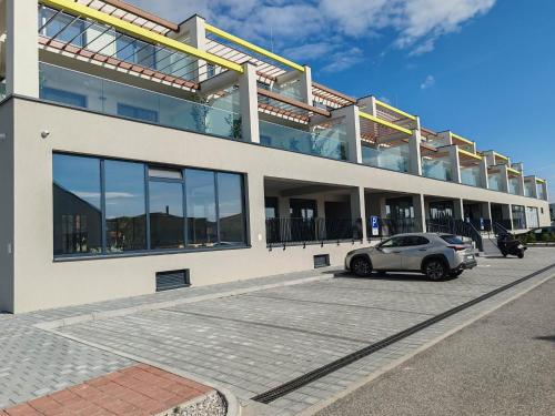 a car parked in a parking lot in front of a building at Sunny apartment208 in Dunajská Streda