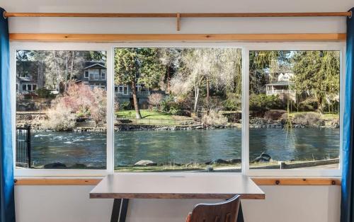 a window with a table and a view of a river at Cozy Studio Cottage on the River in Bend