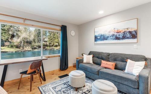 a living room with a couch and a large window at Cozy Studio Cottage on the River in Bend