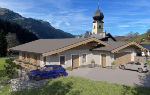 a church with two cars parked in front of it at Apartment Kirchfeld in Aurach bei Kitzbuhel