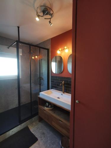 a bathroom with a sink and a shower at La coccinelle in Gujan-Mestras