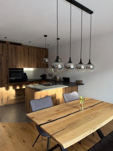 a kitchen with a wooden table and some lights at Apartment Kirchfeld in Aurach bei Kitzbuhel