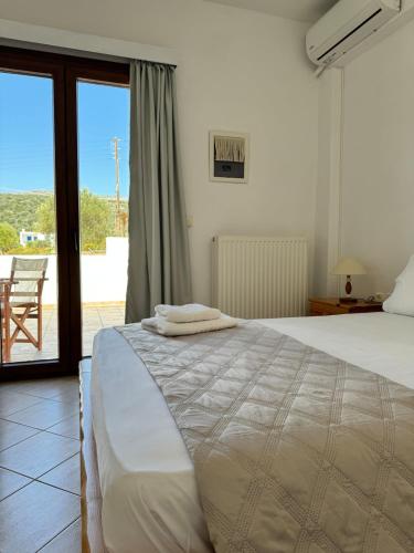 a bedroom with a bed with towels on it at Limnes Seaside Studio in Ligaridia