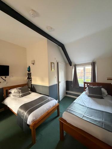a bedroom with two beds and a window at The Bell Inn in Devizes