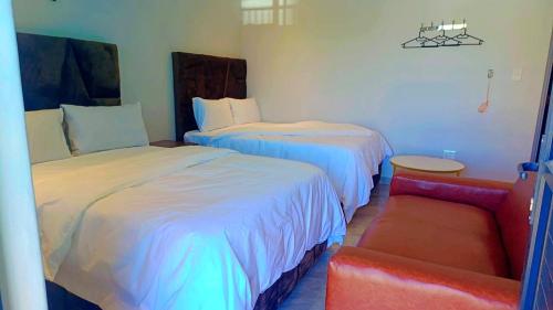 a hotel room with two beds and a red couch at Ijumba Signature Hotel in Bellville