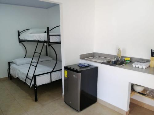 a kitchen with a bunk bed next to a sink at Casa Debut Surf Place 2 in Parrita