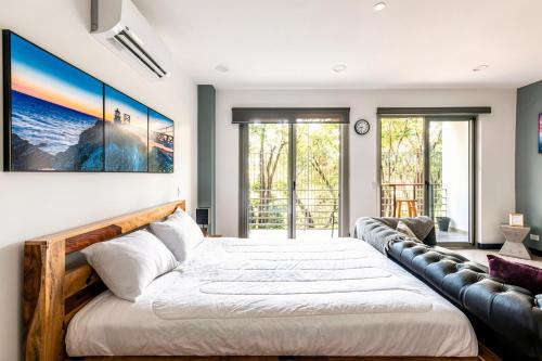 a bedroom with a large bed and a couch at Urban Flats Studios by Corporate Stays in San José