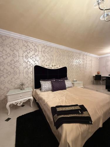 a bedroom with a large bed and a wall at Lily Rose villa in Karlovy Vary