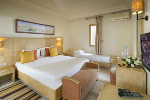 a hotel room with a large bed and a television at Ksar El Jerid in Tozeur