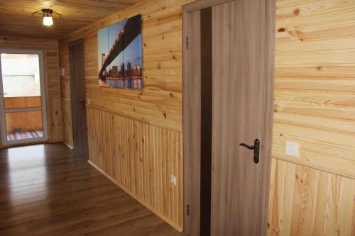 a hallway in a log cabin with a television on the wall at U Bogdana in Yaremche