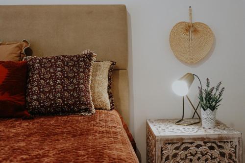 a bedroom with a bed and a table with a lamp at Peace In Azores in Pico da Pedra