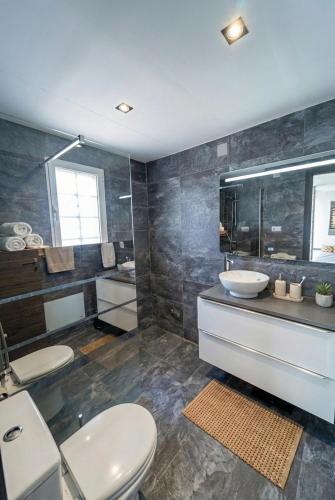 a bathroom with two sinks and a toilet and a mirror at Villa Baena in Granada