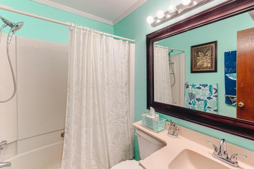 a bathroom with a shower and a sink and a mirror at ABSS102 Seaspray 224 in Atlantic Beach