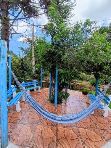 a couple of blue benches in a park at Residencial Saldanha in Gramado