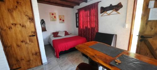 ein kleines Zimmer mit einem kleinen Bett und einem Tisch in der Unterkunft CabañaPaz in Santa Rosa de Calamuchita