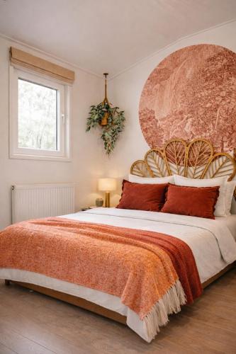 a bedroom with a large bed and a window at Natuurhuisje in het bos met rustige ligging en ruime tuin stijlvol ingericht StayatSas Sam in Epe