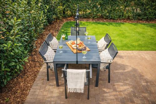 a blue table with chairs and food on it at Natuurhuisje in het bos met rustige ligging en ruime tuin stijlvol ingericht StayatSas Sam in Epe