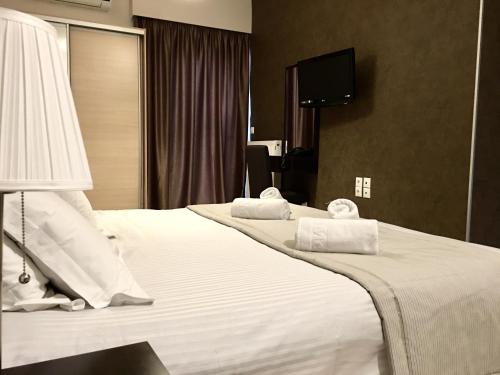 a hotel room with two beds and a flat screen tv at Mc Queen Rooms & Apartments in Athens