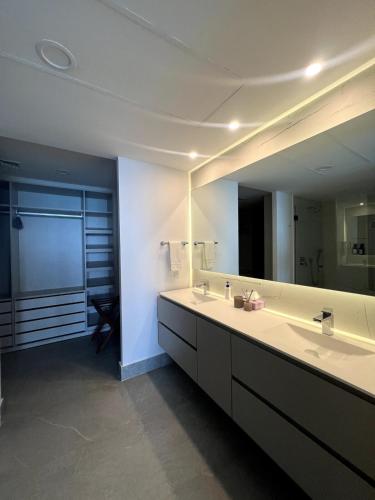 a bathroom with a sink and a large mirror at Bantay 5f in Bucerías