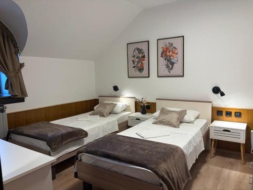 a room with two beds and two tables at Guest house Royal in Čakovec