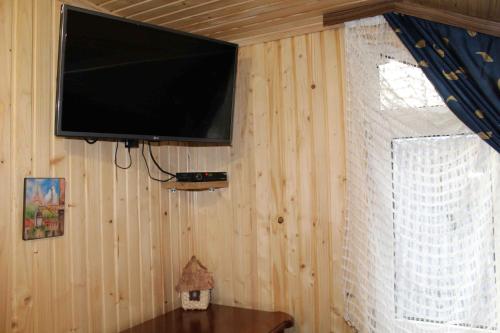 a flat screen tv hanging on a wooden wall at U Bogdana in Yaremche