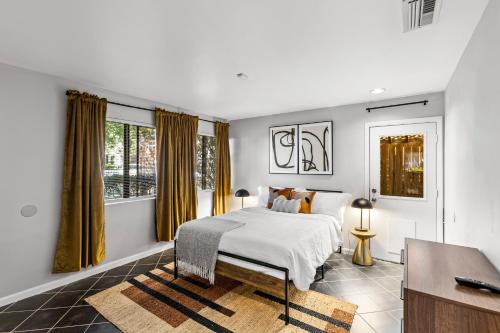 a white bedroom with a bed and a window at Beautiful home by Medical ctr, Rice, Museums in Houston