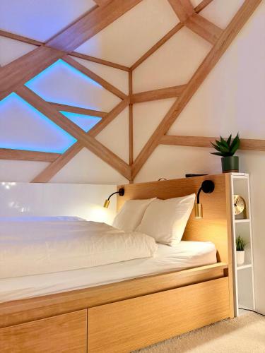 a bedroom with a bed with a wooden headboard at LelleBay in Balatonlelle