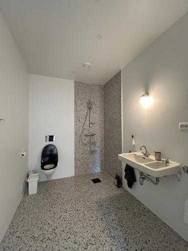 a white bathroom with a sink and a shower at Seaside apartment in Volda