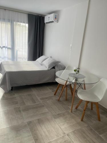 a bedroom with a bed and two chairs and a table at Depto temporal in Morón