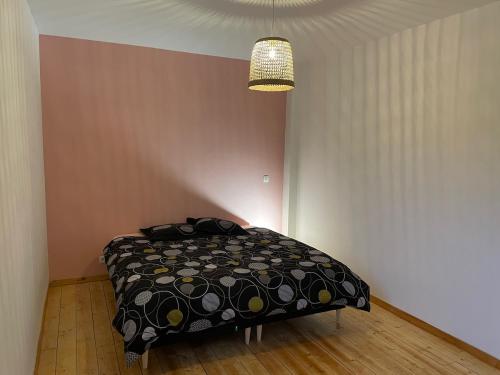 a bedroom with a bed with a black comforter at Esprit Gare in Haubourdin