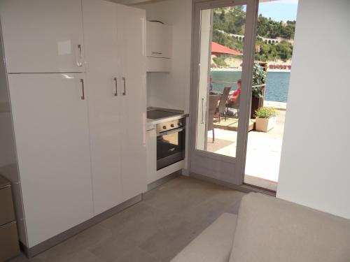 a kitchen with white cabinets and a view of the water at Les pieds dans la mer Best place in Villefranche-sur-Mer