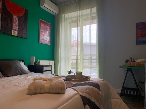 a bedroom with a bed with a green wall at Vespro 1 Apartment - near the Greek theater in Syracuse