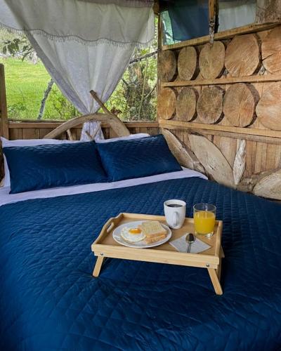 a tray of food on a bed with a breakfast at Cabaña el Leñador in Santa Elena