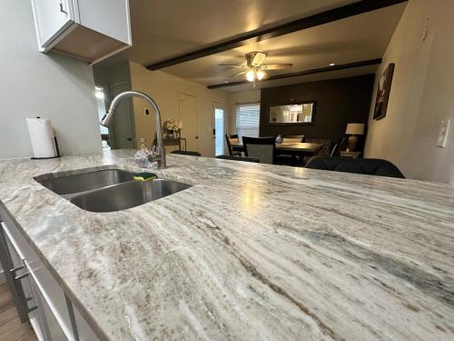 a kitchen counter with a sink and a living room at NEW Modern Retreat in Richardson