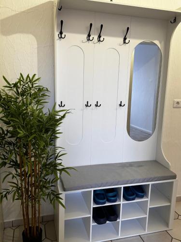 a dressing room with white cabinets and a mirror at Vina Ferienwohnung in Emden