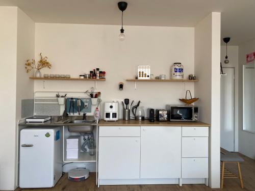 a kitchen with white cabinets and a white refrigerator at Apartment Nina in Hrubá Borša