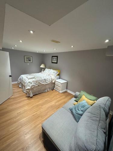 a bedroom with two beds and a couch in it at 2 Bedroom 1 Bathroom Basement Suite in Toronto