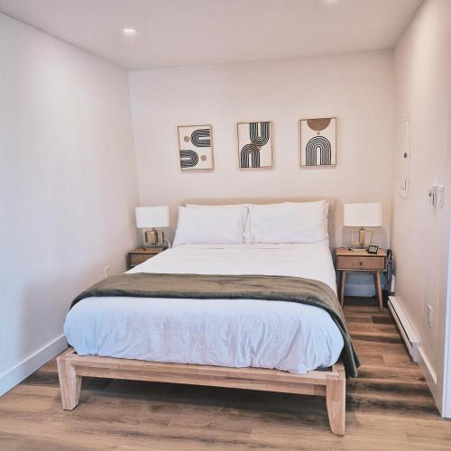 a bedroom with a large bed with two night stands at Modern Nordic Cabin 2 Hot Tub & Views in East LaHave