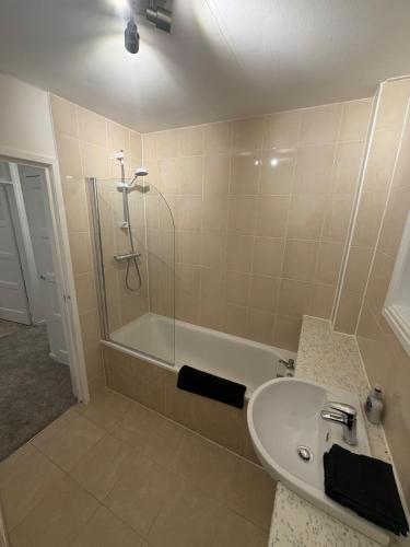 a bathroom with a shower and a sink and a tub at Spacious 2 bed apartment with private parking space in Edinburgh