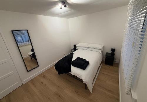 a bedroom with a bed with pillows and a mirror at Spacious 2 bed apartment with private parking space in Edinburgh