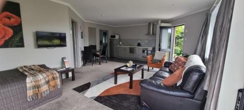 a living room with a couch and a table at Rosandra Retreat 1 in New Plymouth
