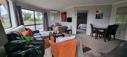 a living room with a couch and a dining room at Rosandra Retreat 1 in New Plymouth