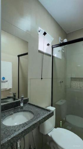 a bathroom with a sink and a toilet at Villa Safira Residence in Caxias das Aldeias Altas