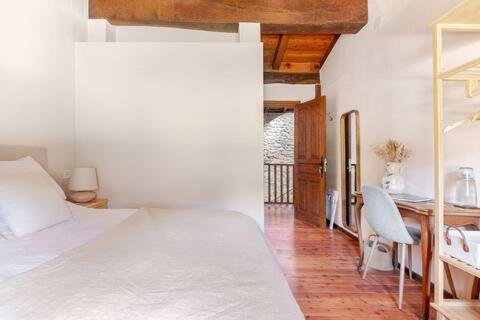a bedroom with a bed and a desk and a table at Golindo Goikoa in Getaria
