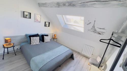 a bedroom with a blue bed in a white room at TOP HOST Les Perles des châteaux in Mer