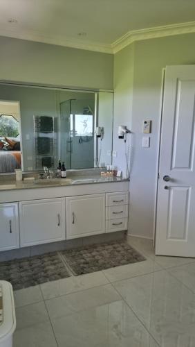 a bathroom with a sink and a large mirror at Rosandra Retreat 2 in New Plymouth