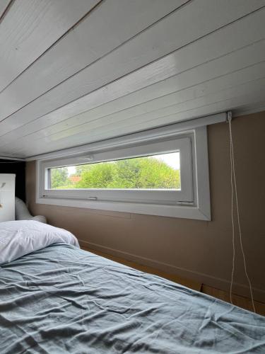 a window in a bedroom with a bed in it at Le repère d Howardries in Brunehaut